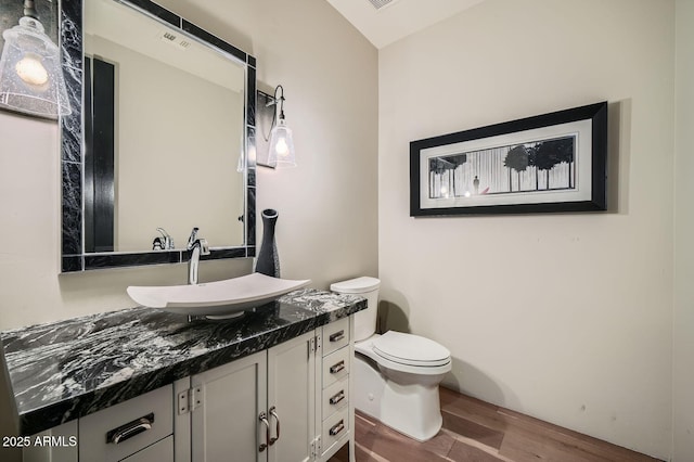 bathroom with vanity, hardwood / wood-style flooring, and toilet