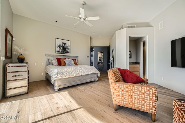 bedroom featuring connected bathroom, light hardwood / wood-style floors, and ceiling fan