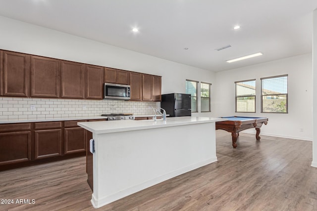 kitchen with tasteful backsplash, stainless steel appliances, a kitchen island with sink, dark wood-type flooring, and billiards