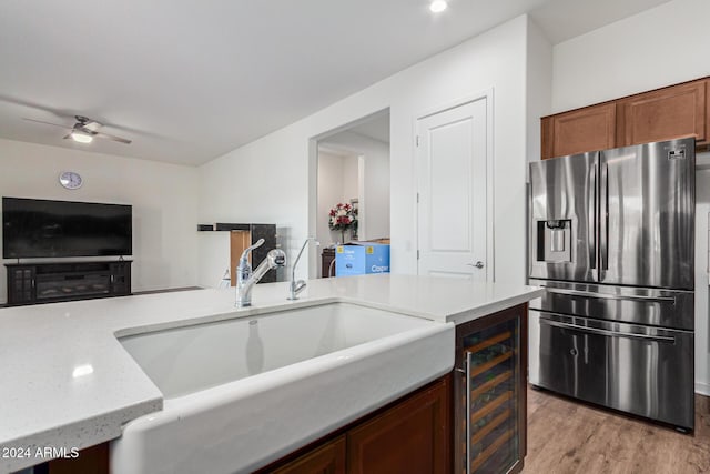 kitchen featuring ceiling fan, sink, light hardwood / wood-style flooring, stainless steel fridge with ice dispenser, and wine cooler