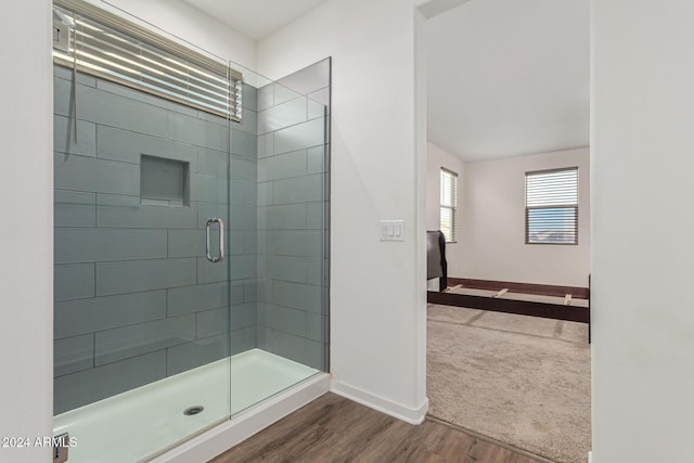 bathroom with wood-type flooring and a shower with door