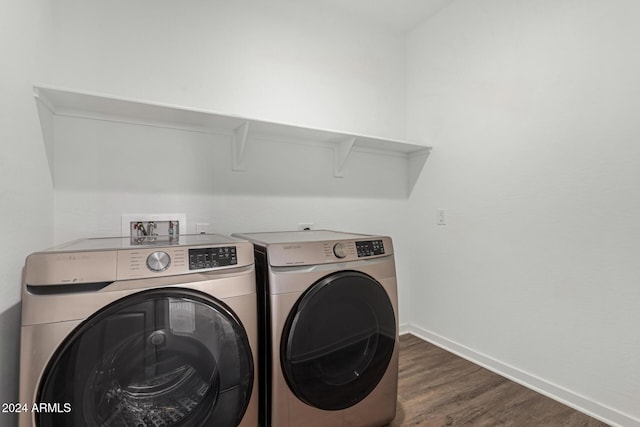 clothes washing area featuring dark wood-type flooring and washing machine and clothes dryer