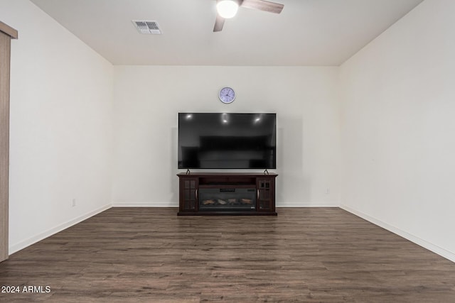 unfurnished living room featuring ceiling fan and dark hardwood / wood-style floors