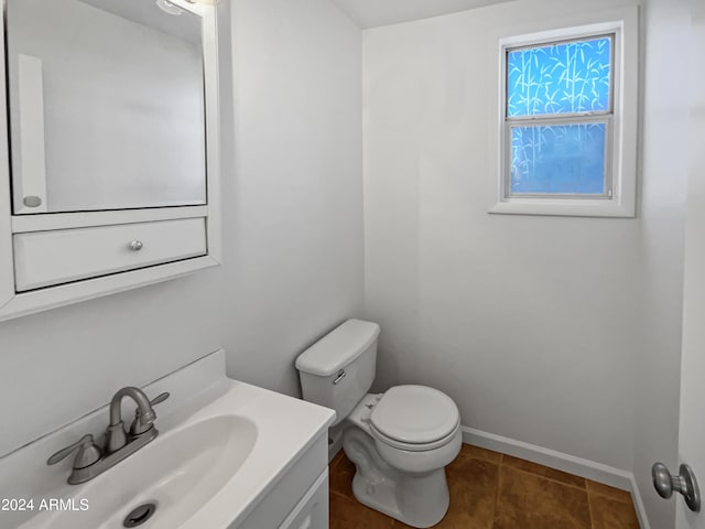 bathroom with tile floors, vanity, and toilet