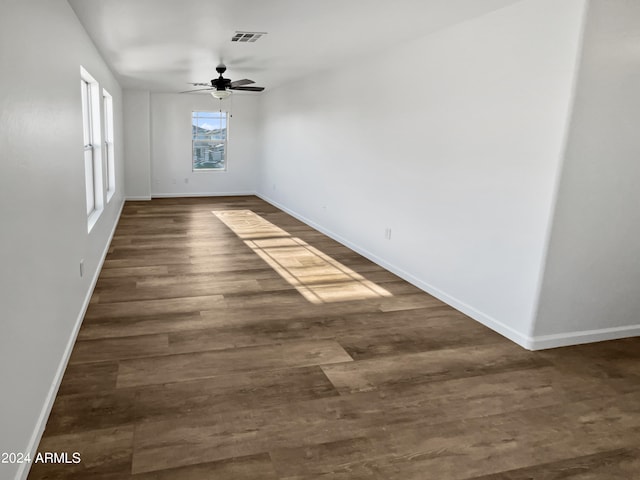 empty room with dark hardwood / wood-style flooring and ceiling fan