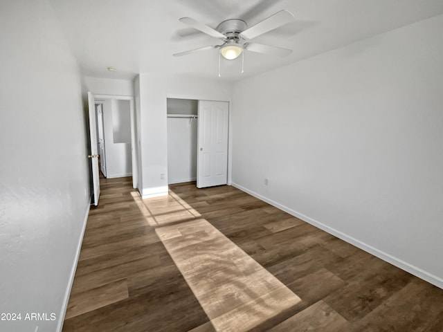 unfurnished bedroom featuring a closet, dark wood-type flooring, and ceiling fan