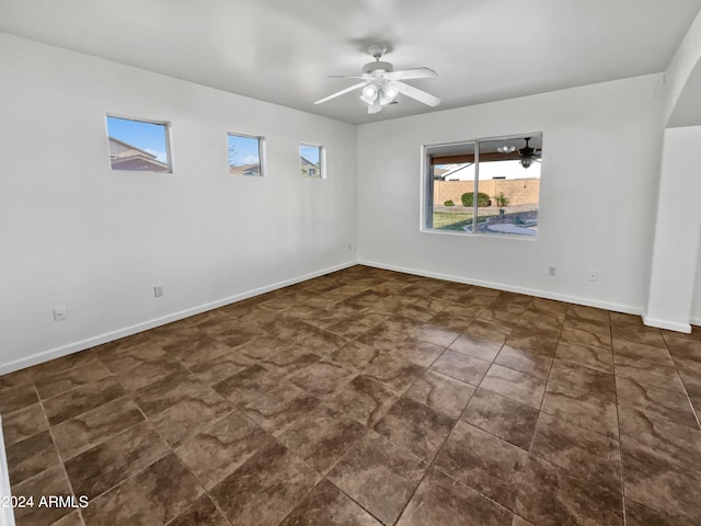 tiled spare room featuring ceiling fan