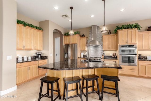 13336 W Via Caballo Blanco, Peoria, AZ 85383 - kitchen featuring wall chimney range hood, a sink, light brown cabinetry, arched walkways, and stainless steel appliances