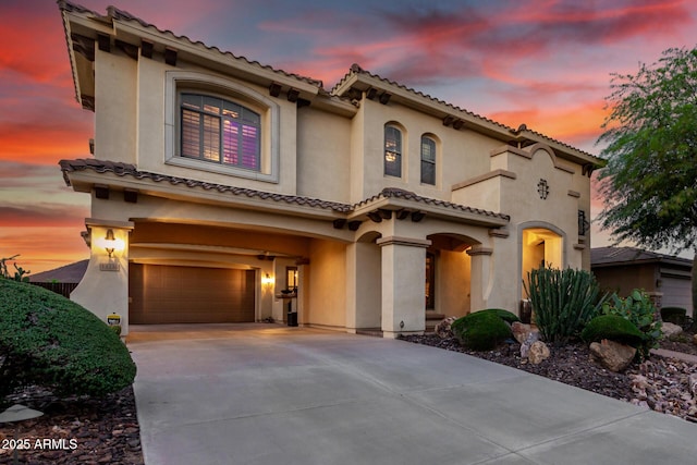 13336 W Via Caballo Blanco, Peoria, AZ 85383 - mediterranean / spanish-style house featuring an attached garage, a tile roof, stucco siding, and driveway