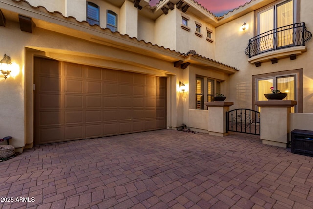 13336 W Via Caballo Blanco, Peoria, AZ 85383 - exterior space featuring a balcony, stucco siding, an attached garage, a tile roof, and decorative driveway