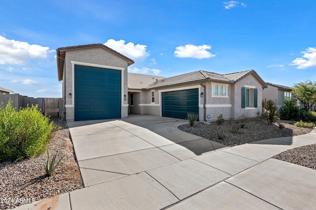 ranch-style house with a tiled roof, an attached garage, and stucco siding