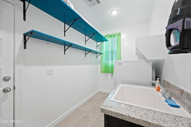 laundry room featuring light tile patterned floors and sink