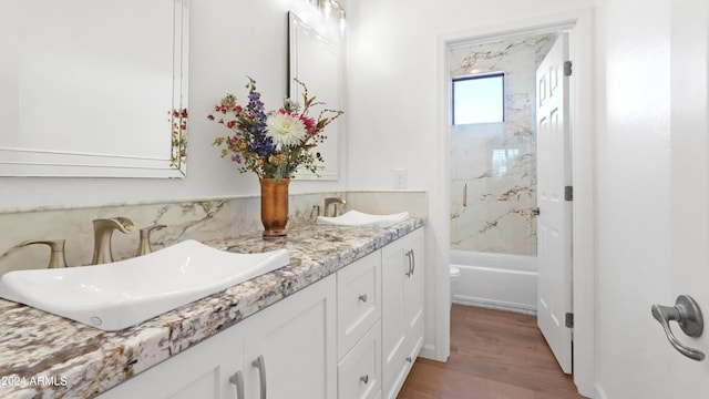 bathroom featuring tiled shower / bath combo, vanity, and hardwood / wood-style flooring