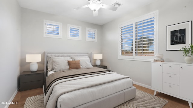 bedroom featuring dark wood-type flooring, ceiling fan, and multiple windows