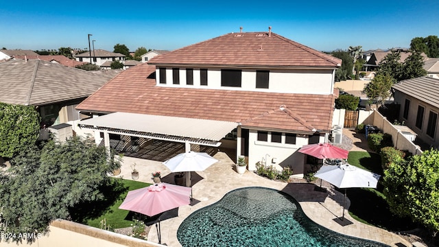 back of house with a fenced in pool and a patio