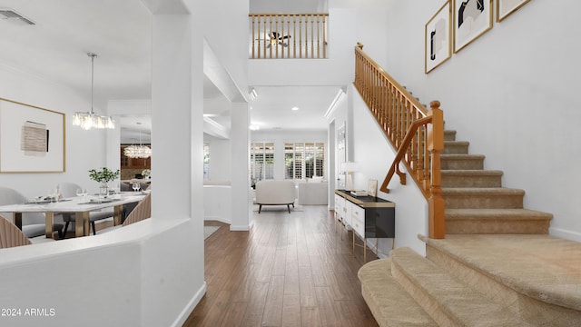 entryway with dark wood-type flooring and an inviting chandelier