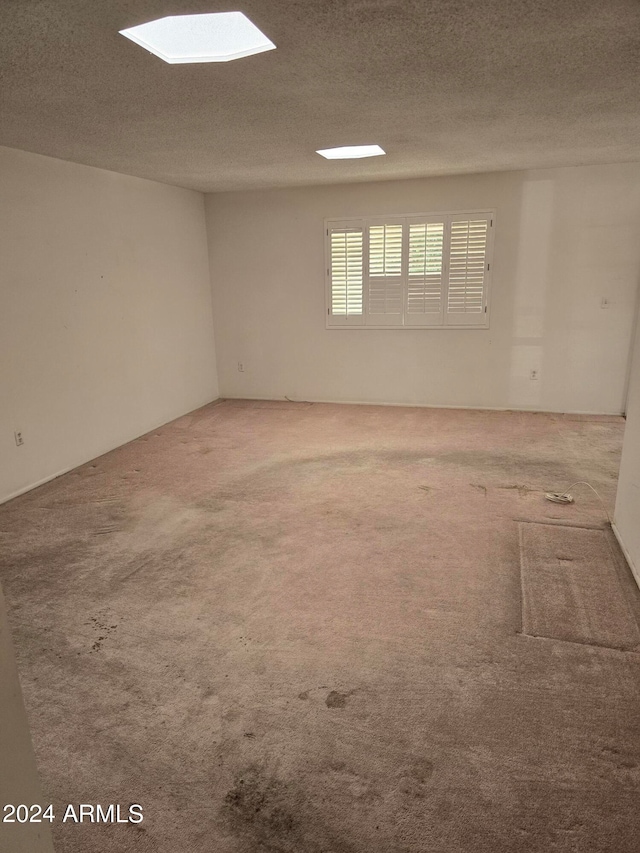 carpeted spare room with a textured ceiling