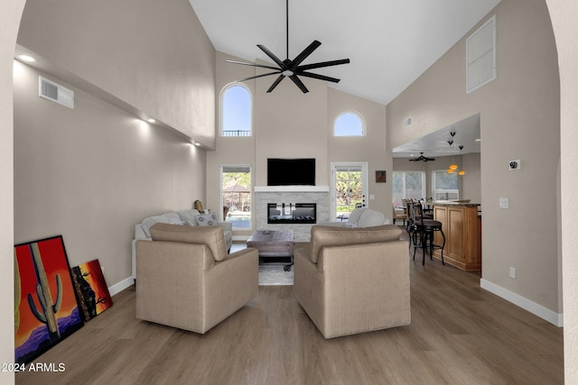 living room with hardwood / wood-style floors, high vaulted ceiling, and ceiling fan