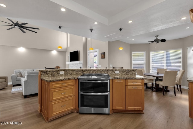 kitchen featuring a kitchen island, hanging light fixtures, wood-type flooring, stainless steel electric range, and ceiling fan