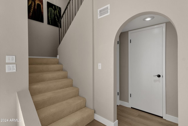 staircase with hardwood / wood-style floors