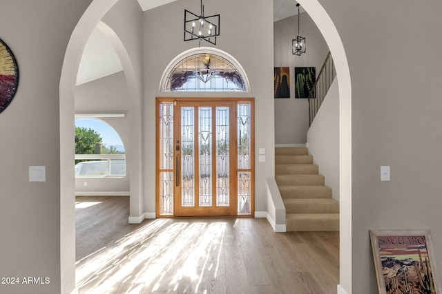 entrance foyer featuring a chandelier, light hardwood / wood-style flooring, and high vaulted ceiling