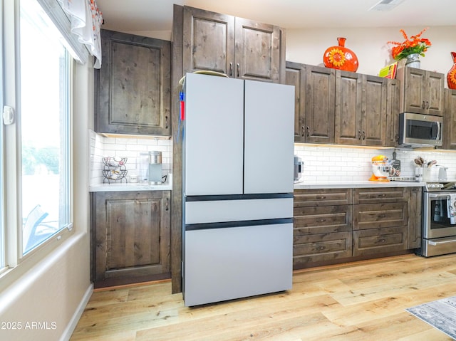 kitchen featuring decorative backsplash, appliances with stainless steel finishes, and plenty of natural light