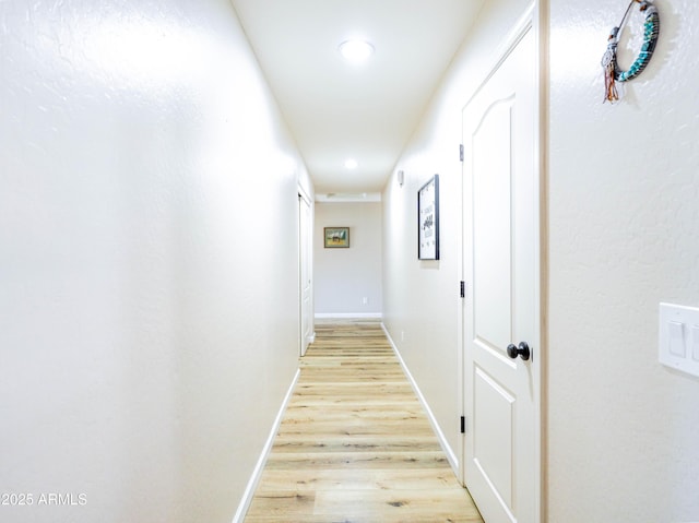 hallway featuring recessed lighting, baseboards, and light wood-style flooring