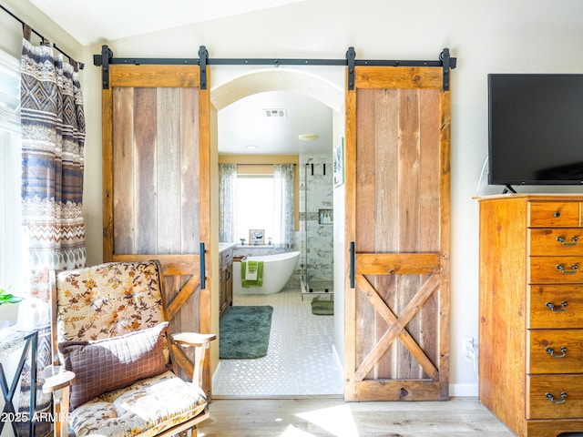 bathroom featuring a shower stall, wood finished floors, a freestanding tub, lofted ceiling, and visible vents