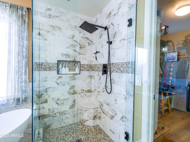 full bathroom with wood finished floors, a freestanding bath, and a stall shower