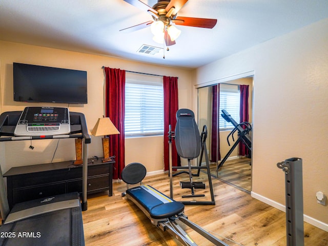 workout area with wood finished floors, baseboards, a ceiling fan, and visible vents