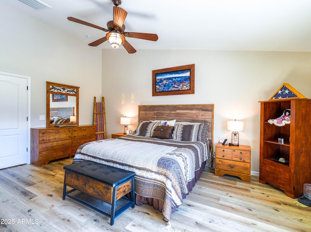 bedroom with visible vents, vaulted ceiling, wood finished floors, and a ceiling fan