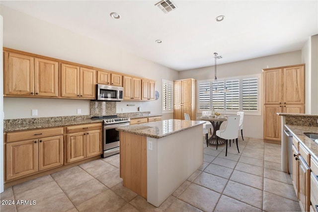 14428 E Monument Dr, Scottsdale, AZ 85262 - kitchen featuring visible vents, light brown cabinetry, a kitchen island, light stone counters, and stainless steel appliances