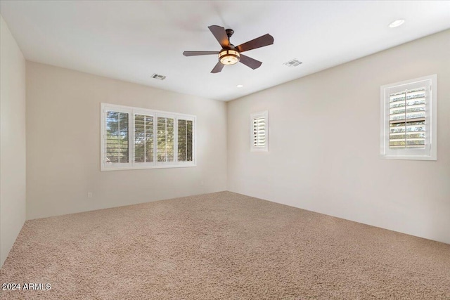 carpeted spare room featuring ceiling fan