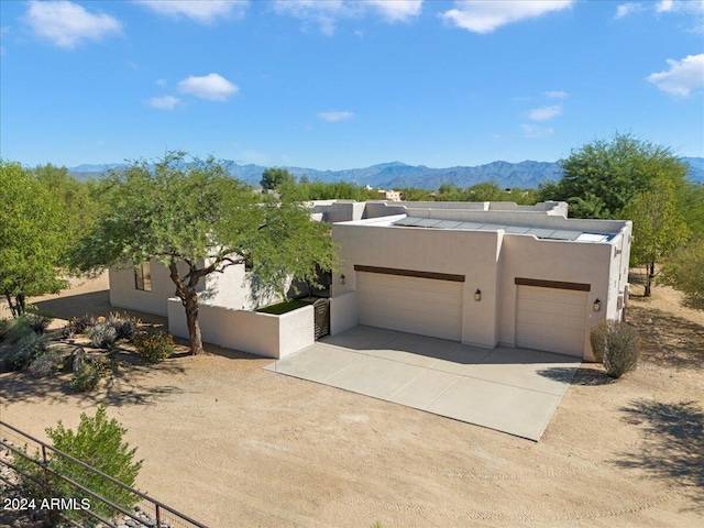 adobe home featuring a garage and a mountain view