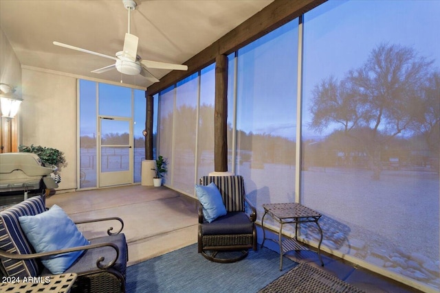 sunroom / solarium with a water view and ceiling fan