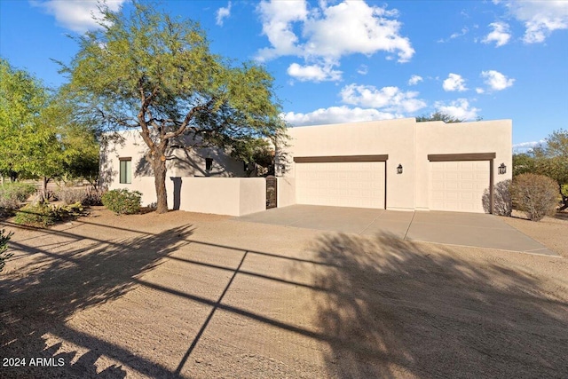 pueblo-style home featuring a garage