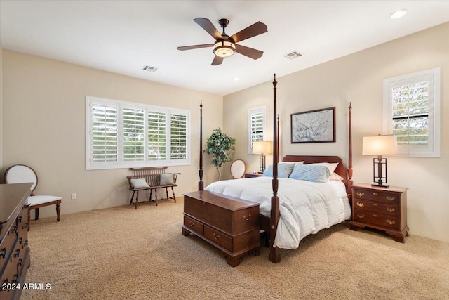 carpeted bedroom with ceiling fan and multiple windows