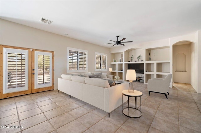 14428 E Monument Dr, Scottsdale, AZ 85262 - living room with ceiling fan, built in shelves, light tile patterned floors, a healthy amount of sunlight, and visible vents