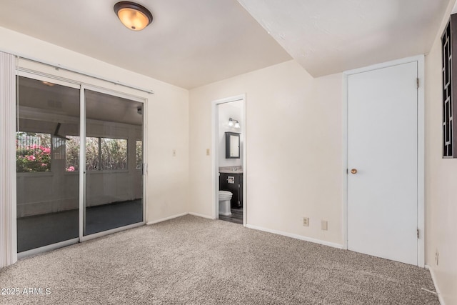 unfurnished bedroom featuring carpet flooring, baseboards, and ensuite bathroom