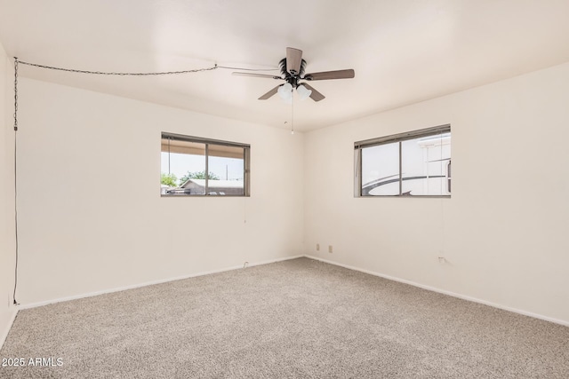 spare room with ceiling fan, carpet flooring, and baseboards
