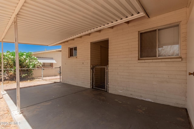 view of patio with an attached carport and fence
