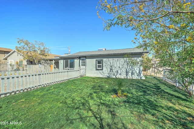 rear view of property featuring a yard