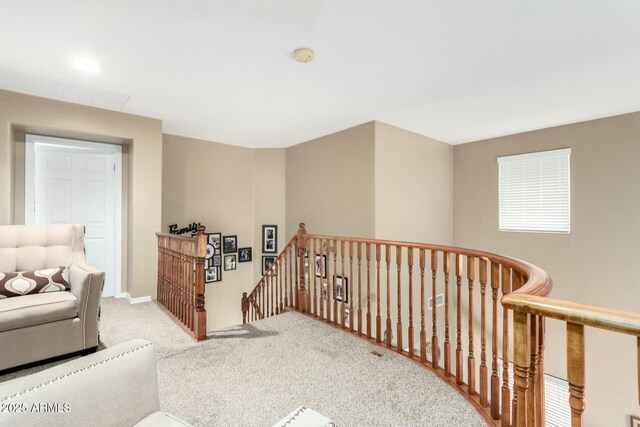 sitting room featuring baseboards, an upstairs landing, and carpet