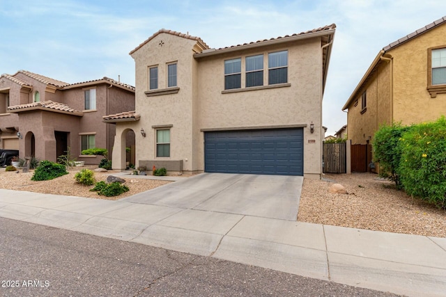 mediterranean / spanish home featuring fence, a tiled roof, stucco siding, an attached garage, and driveway