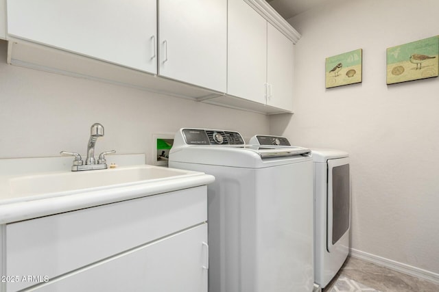 laundry room with baseboards, cabinet space, a sink, and independent washer and dryer