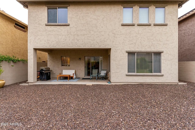 back of house with a patio, stucco siding, and fence