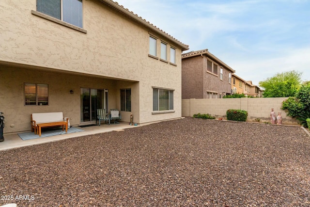 back of house with a patio, stucco siding, and fence
