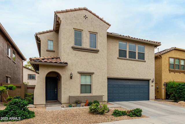 view of front of house featuring a tile roof, concrete driveway, fence, a garage, and stucco siding