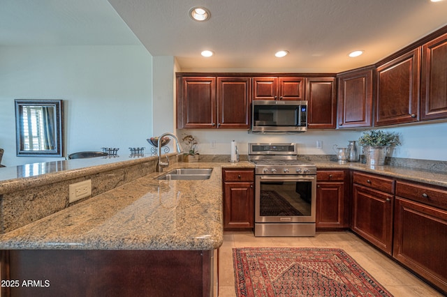 19700 N 76th St Unit 2001, Scottsdale, AZ 85255 - kitchen with a peninsula, recessed lighting, appliances with stainless steel finishes, a sink, and light stone counters