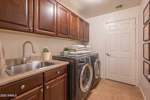 19700 N 76th St Unit 2001, Scottsdale, AZ 85255 - washroom featuring washer and clothes dryer, a sink, a textured ceiling, visible vents, and cabinet space